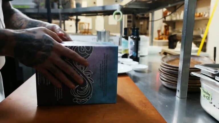 Opening a Tierra Callada bag-in-box of olive oil in a restaurant kitchen